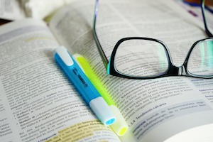 Lehrmaterial mit Textmarkern und Brille