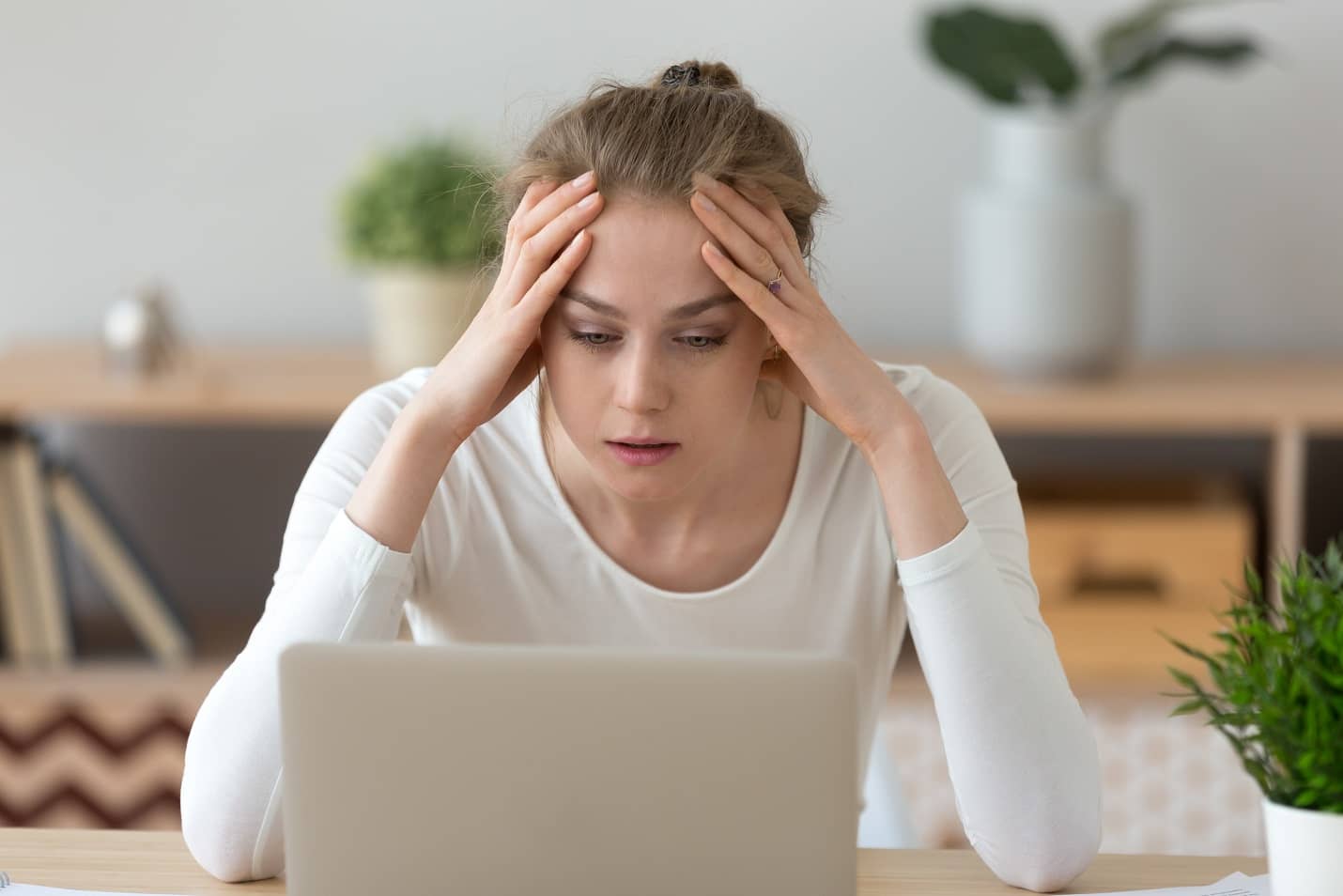 Durchhänger beim Fernstudium - Junge Frau betrachtet etwas ermüdet einen Laptop